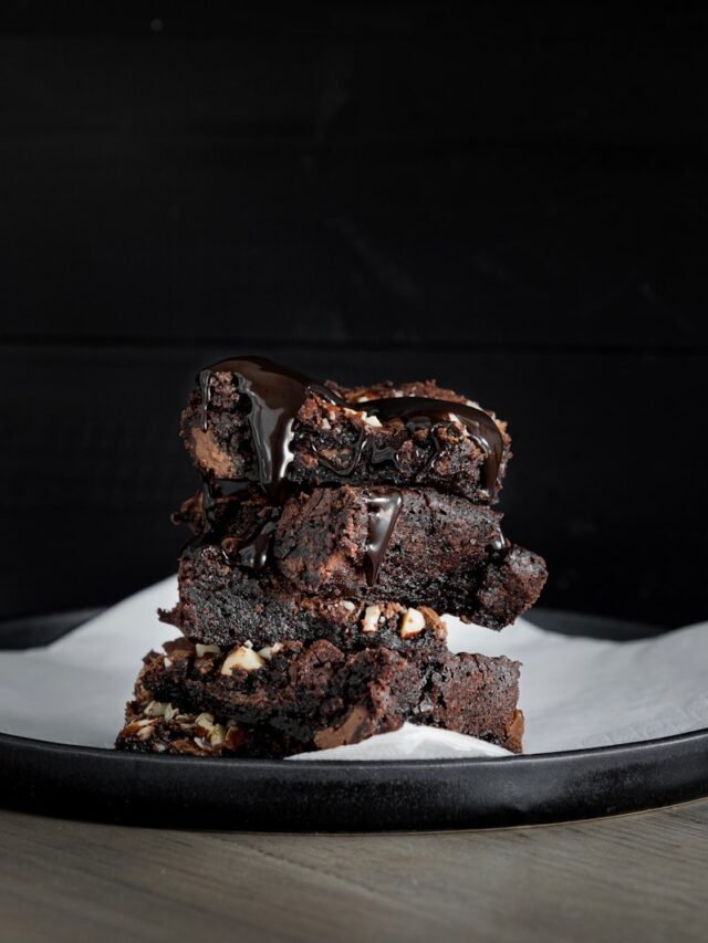 a stack of brownies sitting on top of a white plate